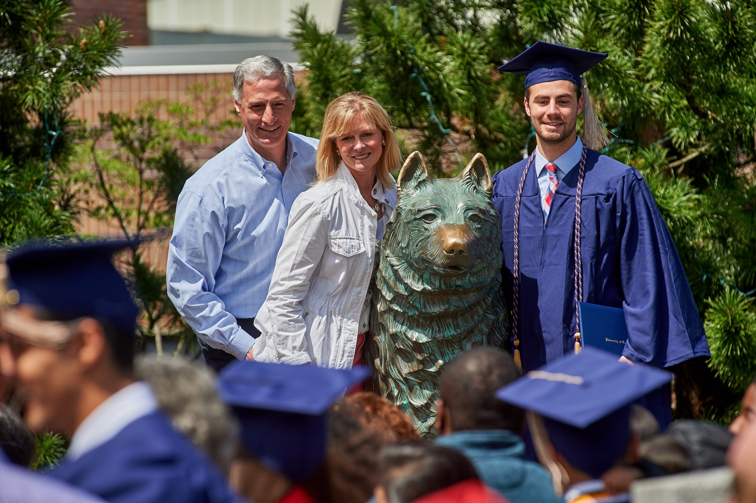 Andrew Patason '17 (BUS) poses for a photo at the husky statue with his parents Denise Patason '86 (BUS) and Andy Patason '86 (BUS) following the School of Business Commencement ceremony on May 7, 2017. (Peter Morenus/UConn Photo)