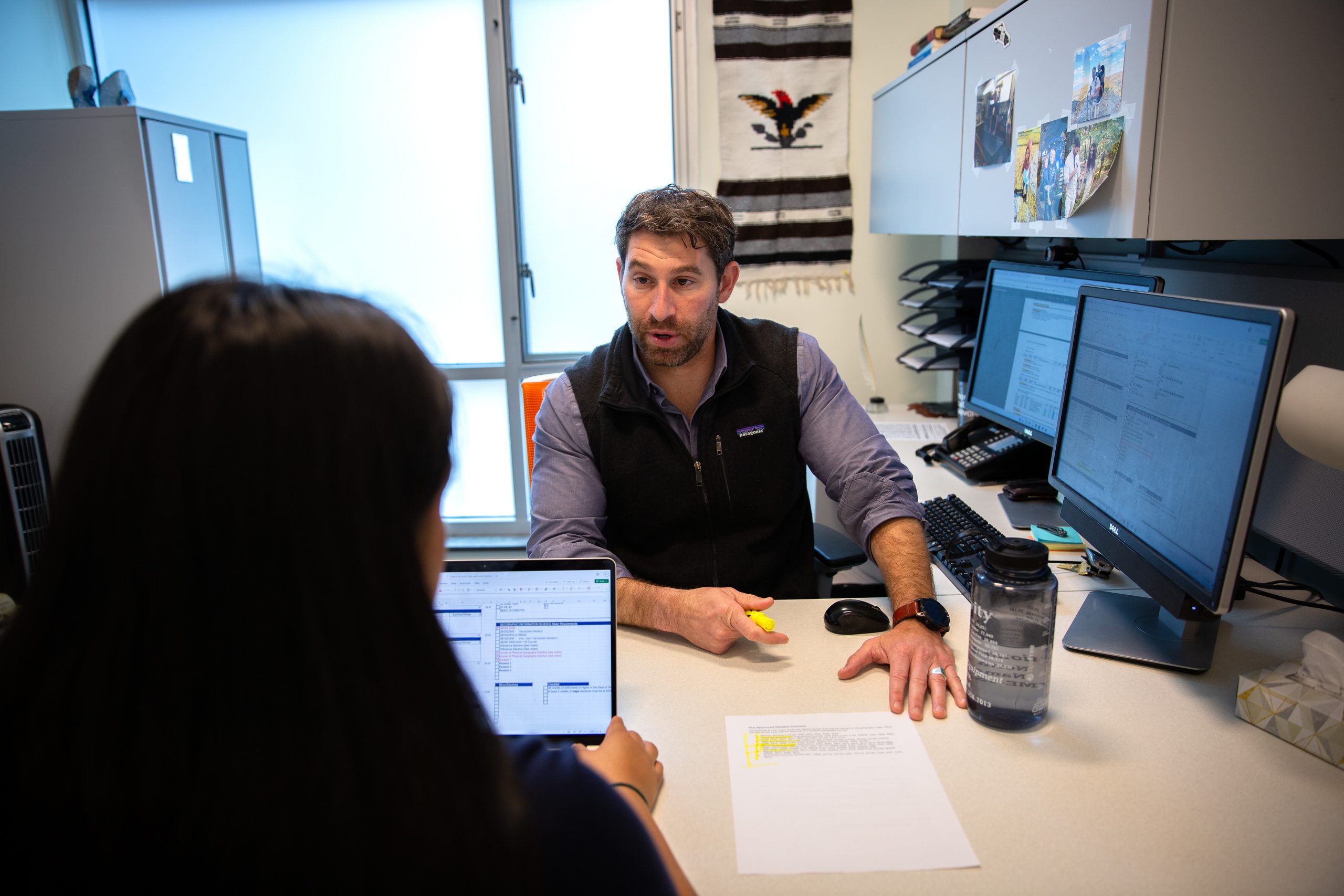 Matthew Donofrio, academic advisor for the departments of geography, sustainability, community, and urban studies and anthropology, meets with geography majors in the CLAS Academic Services Center on Oct. 9, 2024. (Bri Diaz/UConn Photo)