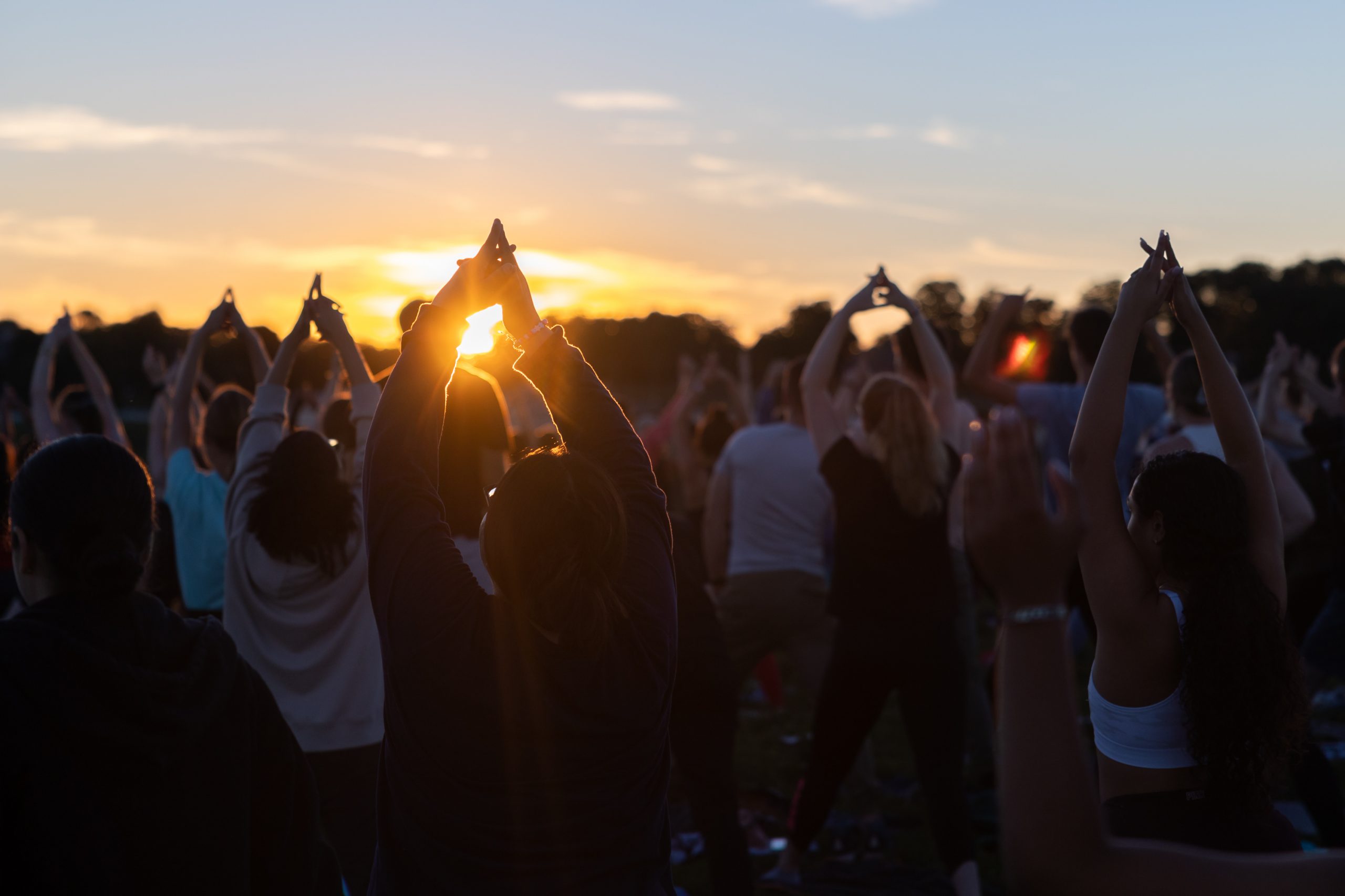 Students gather on Horsebarn Hill for the UConn Rec Center’s Sunset Yoga program on Sept. 2, 2022. (Sydney Herdle/UConn Photo)