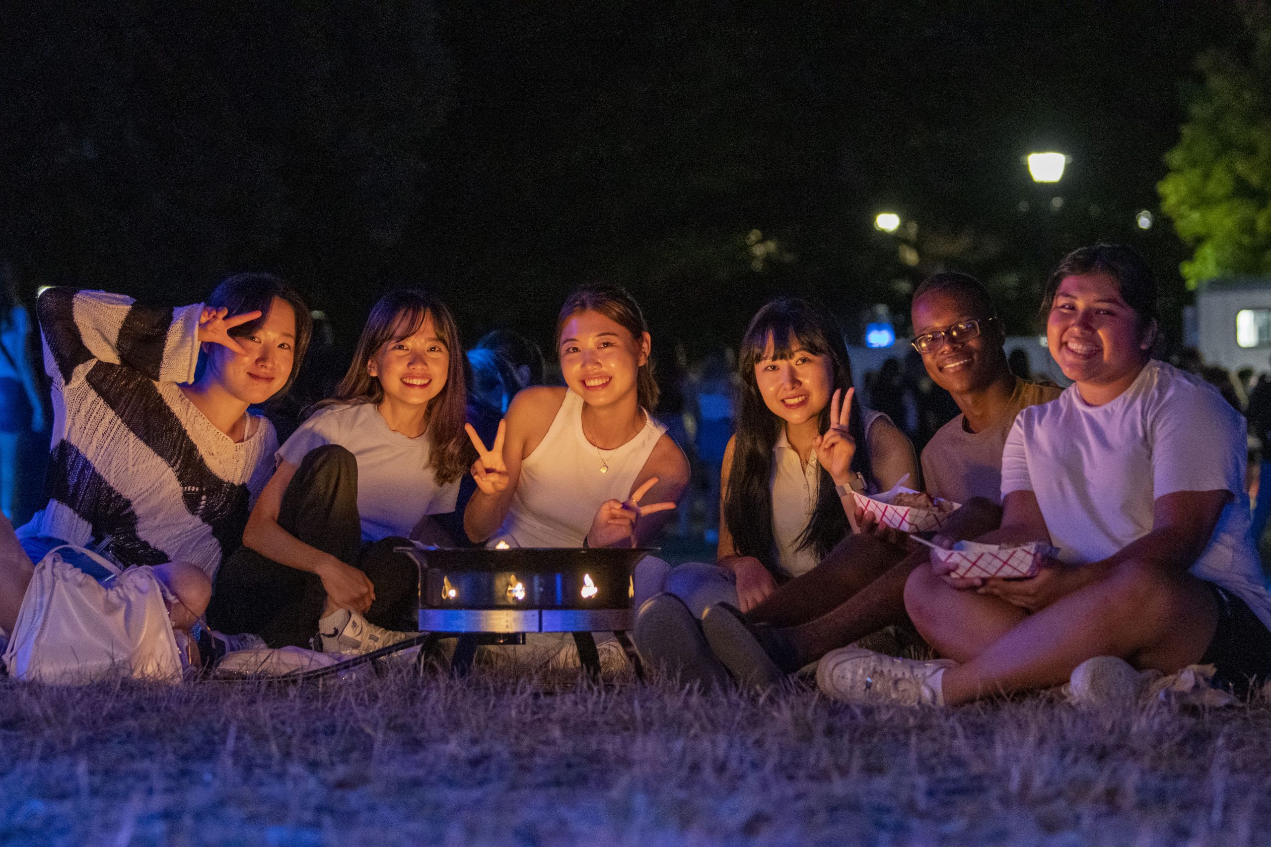 fire-pit220827a190.jpg From left, foreign exchange students Da-in Song, Ruo-Jia Gung, Sumin Jung, Hyemi Gu, Jordan Wabahati ’26 (HSS), and Erika Velasquez ’26 (BUS) taking part in Husky WOW (Week of Welcome) fire-pit and glo-swing event on President’s Field. Aug. 27, 2022. (Sean Flynn/UConn Photo)