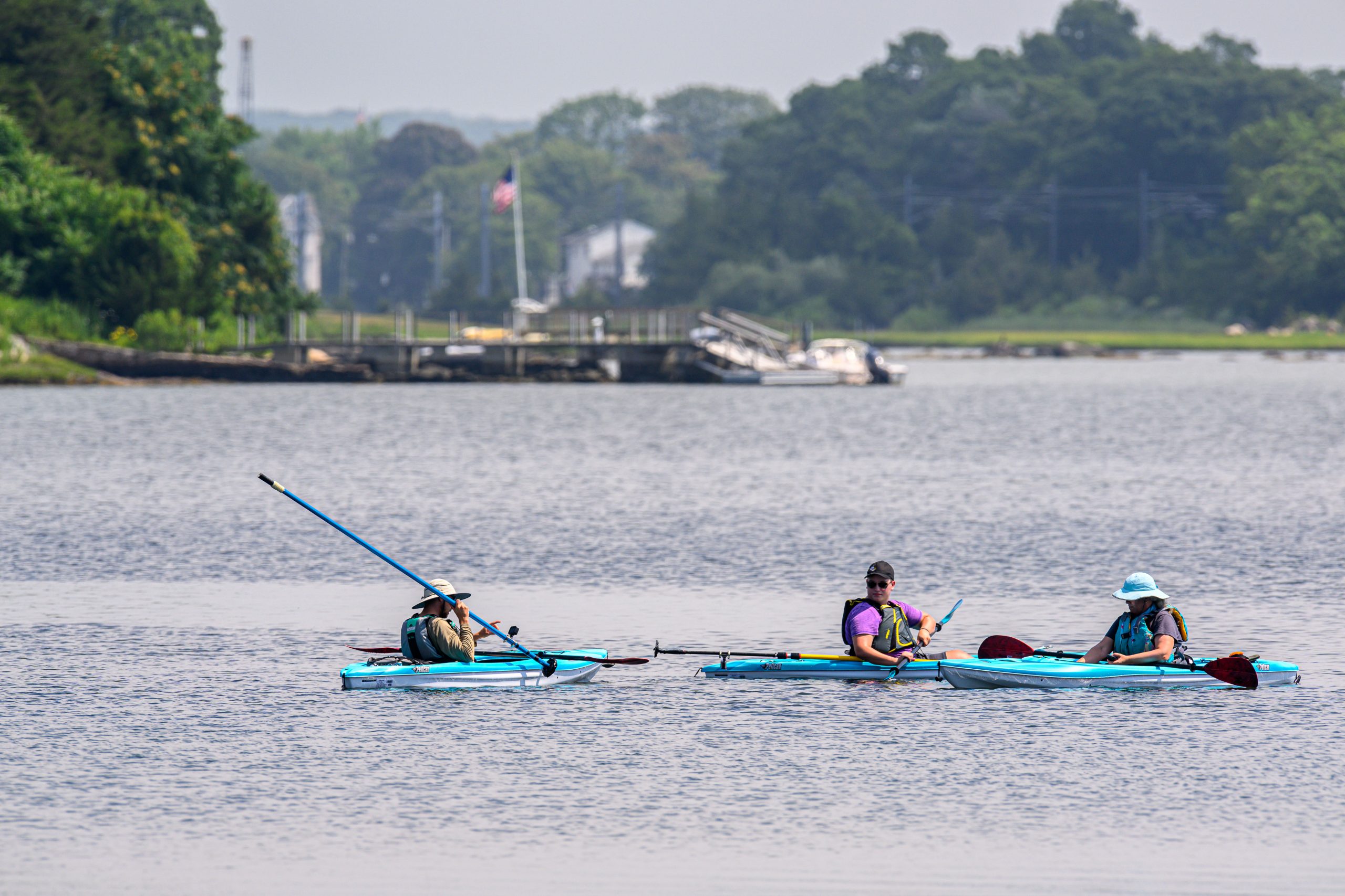 Avery Point campus researchers in kayaks, including Jamie Vaudrey, assess the density of eelgrass by submerging a video camera at the end of a pole at Beebe cove in Noank on July 21, 2022. (Peter Morenus/UConn Photo)